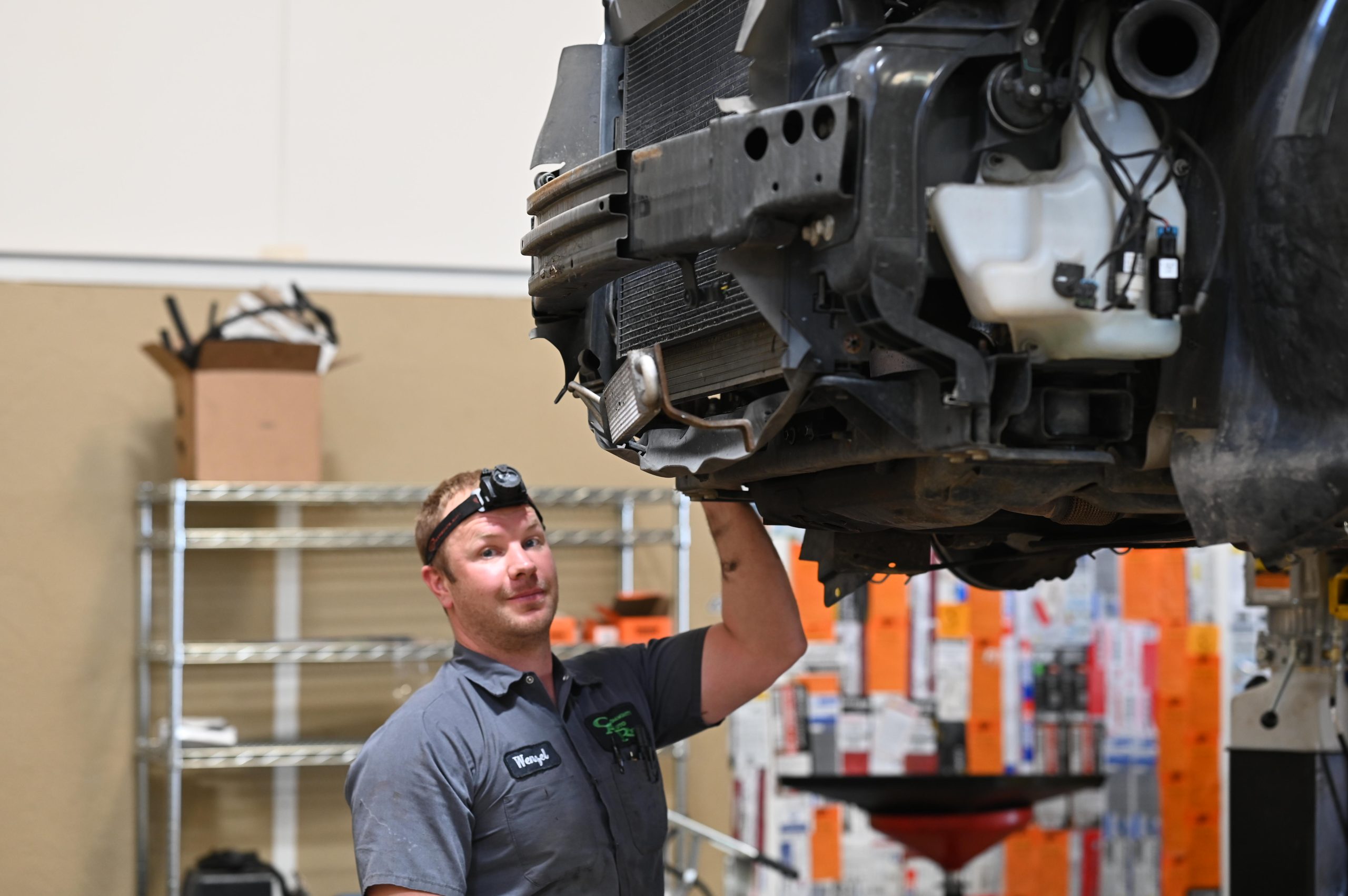 Community Auto Repair technician working beneath a raised vehicle